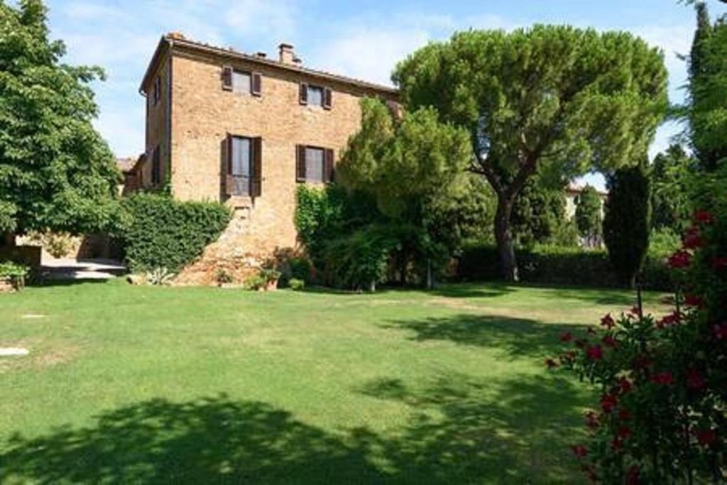 MontisiにあるAgriturismo San Martinoの木の植わる広い庭のある大きなレンガ造りの家
