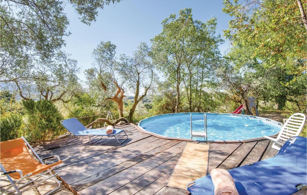 a swimming pool on a wooden deck with chairs at Casale Petrucci in Vacone