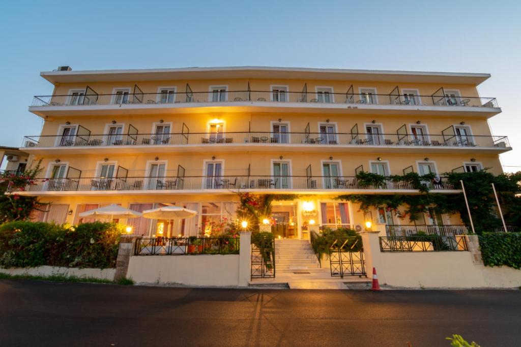 a large white building with lights on it at Aegli Hotel in Perama