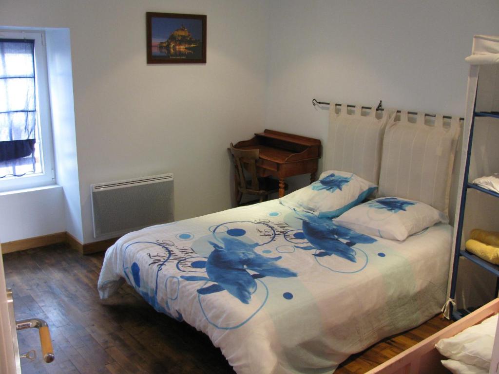 a bedroom with a bed with blue flowers on it at Gîte Aristide Mont Saint Michel in Sacey