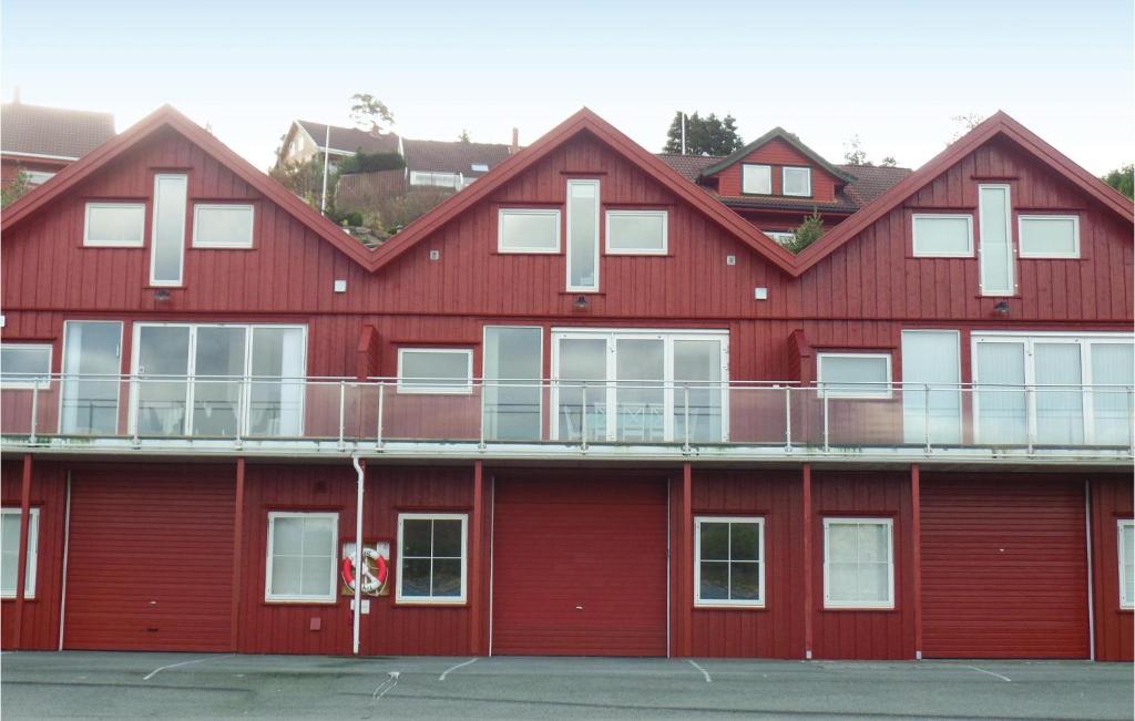 um edifício vermelho com janelas brancas e uma varanda em Stunning Apartment In Lindesnes With Kitchen em Gare