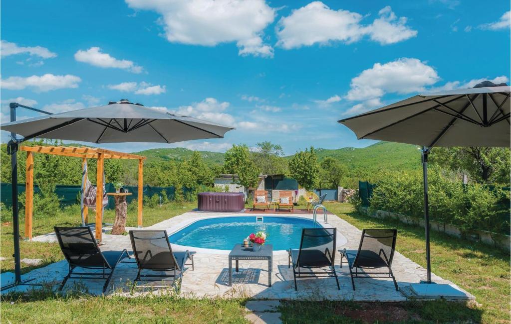 un patio avec des chaises et des parasols à côté d'une piscine dans l'établissement Cozy Home In Unesic With Outdoor Swimming Pool, à Unešić