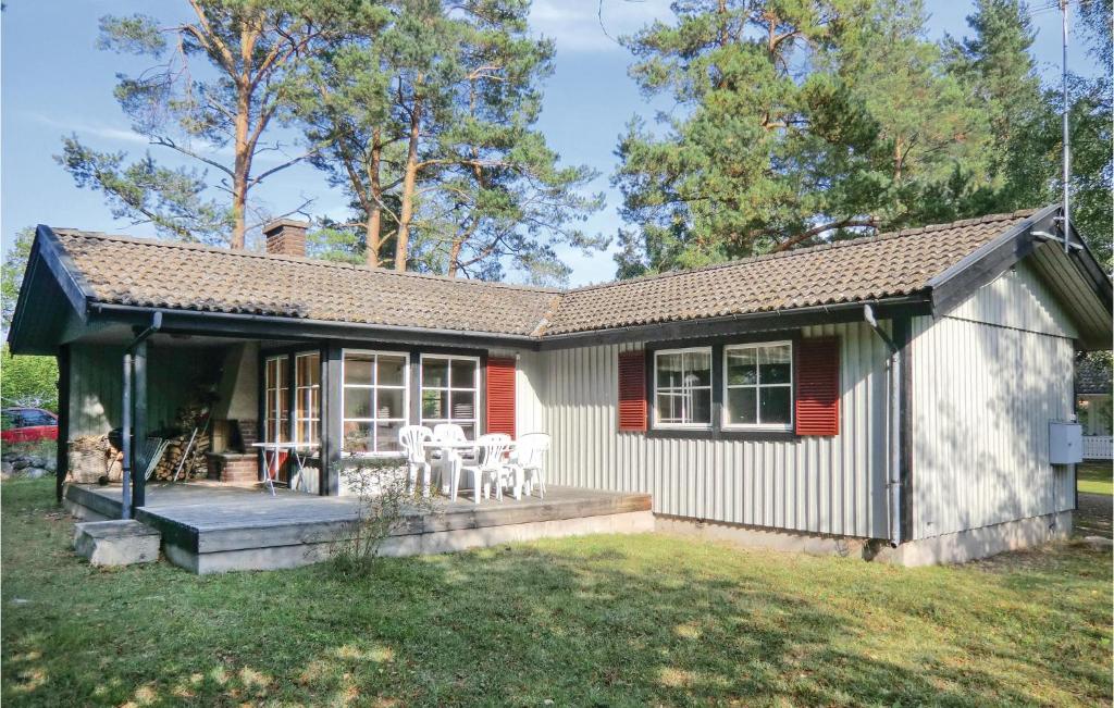 een klein huis met een veranda en een patio bij Cozy Home In Frjestaden With Kitchen in Vanserum