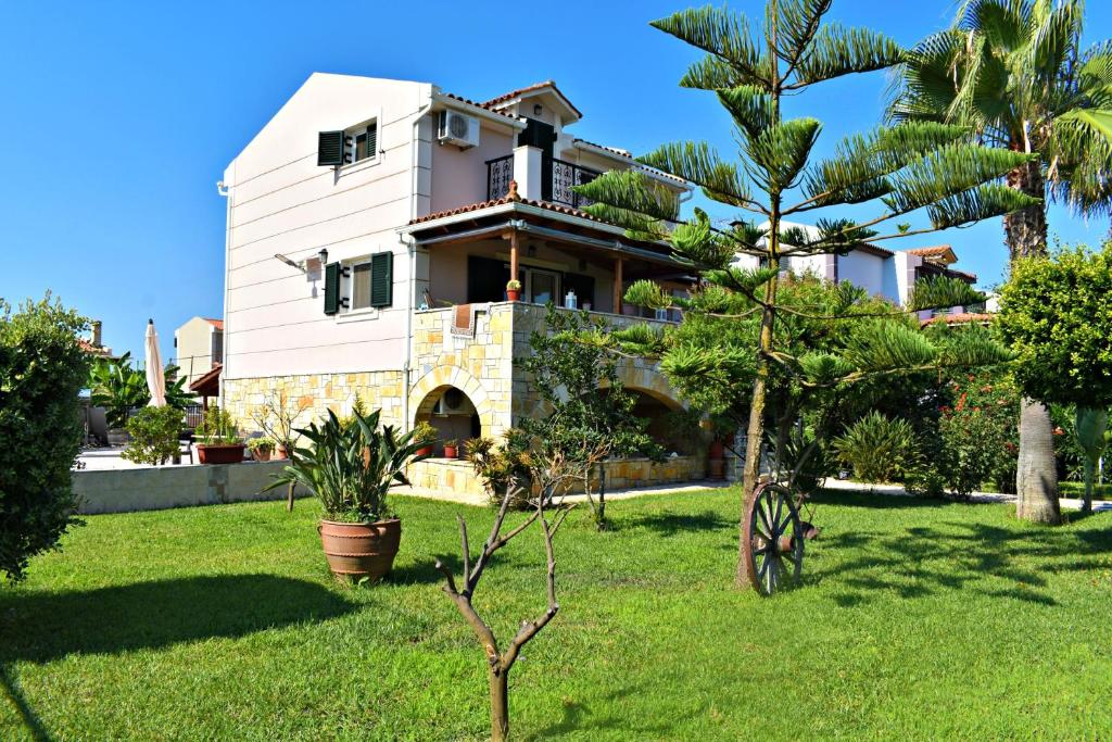 a house with a palm tree in a yard at Kakia 2 Bedroom Apartment in Zakynthos