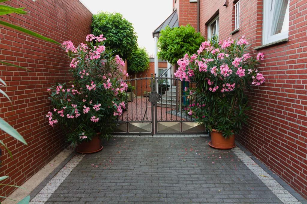 un cancello nero con fiori in vasi su un muro di mattoni di Gästehaus Heitkamp a Lüdinghausen