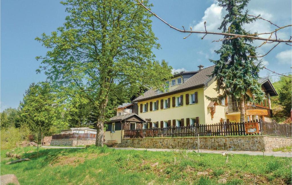 ein großes gelbes Haus mit einem Zaun und Bäumen in der Unterkunft Amazing Apartment In Freiberg With Kitchen in Freiberg