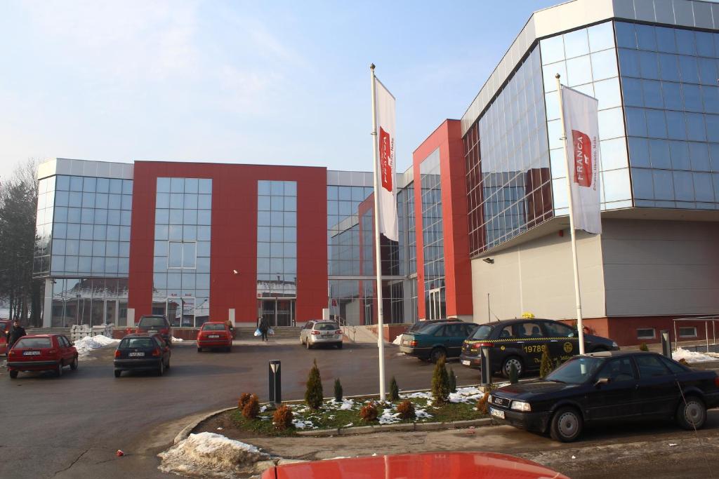 a large building with cars parked in a parking lot at Hotel Franca in Pljevlja