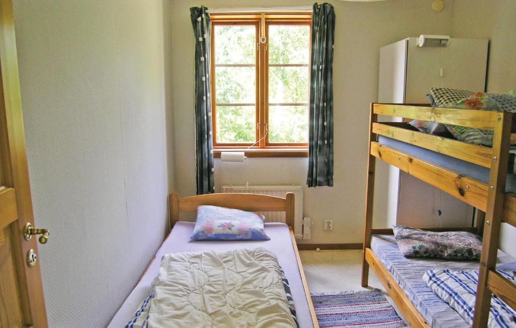a bedroom with two bunk beds and a window at Awesome Home In Broaryd With 2 Bedrooms in Bohult