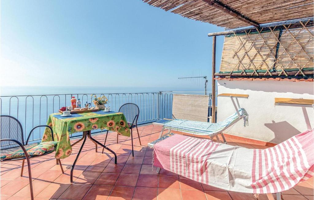 um pátio com uma mesa e cadeiras e o oceano em Gelso Bianco em Praiano