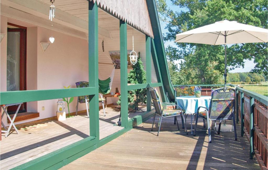 une terrasse en bois avec une table et un parasol dans l'établissement Gorgeous Apartment In Marlow Ot Brnkendorf With Kitchen, à Marlow
