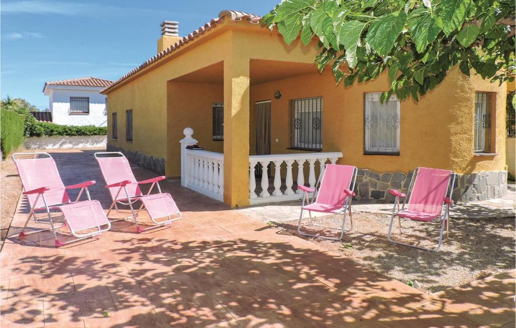 a group of pink chairs sitting in front of a house at Nice Home In Miami Playa With 3 Bedrooms in Miami Platja