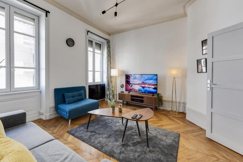 sala de estar con sofá, mesa y TV en NOCNOC - L'Escapade, en Lyon