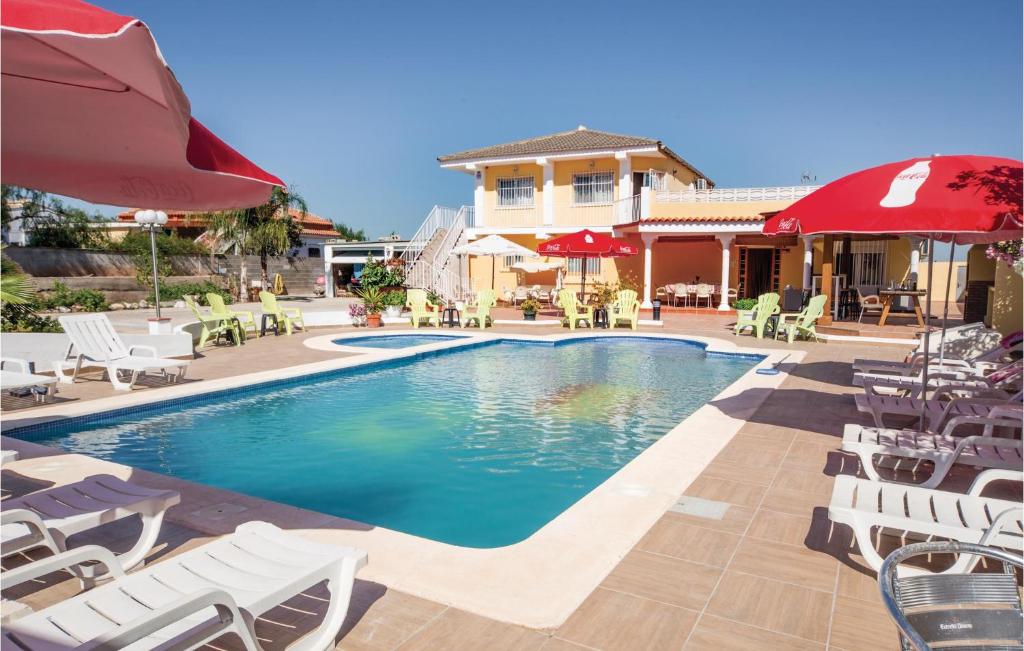 リリアにあるStunning Home In Llria With 4 Bedrooms, Private Swimming Pool And Outdoor Swimming Poolの家の隣のプール(椅子、パラソル付)