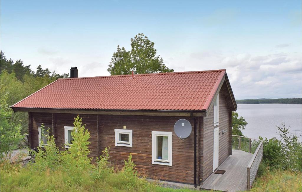 a small house with a red roof next to a body of water at 3 Bedroom Beautiful Home In Vetlanda in Stenberga