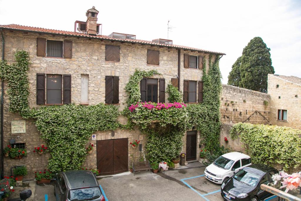 een oud gebouw met bloemen en klimop erop bij B&B Antiche Mura in Tarquinia