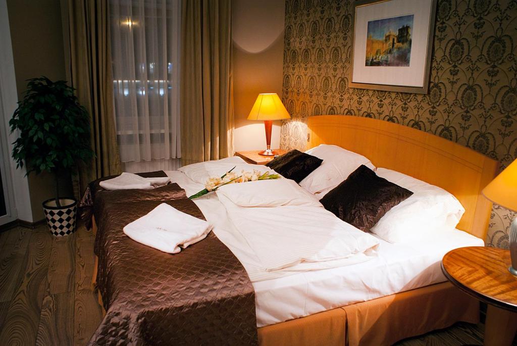 a hotel room with two beds with white sheets at Hotel MCM Plus in Gorzów Wielkopolski