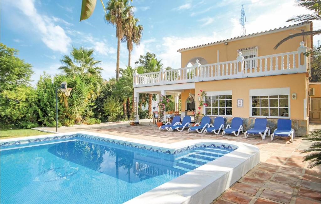 a villa with a swimming pool in front of a house at Finca Tropical in Coín