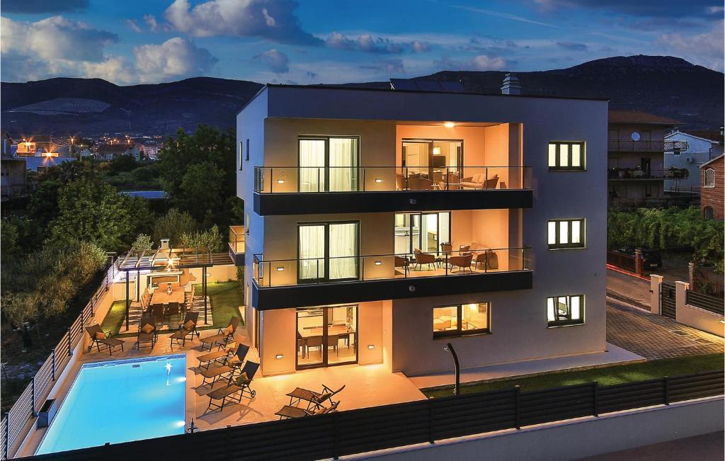 a building with a swimming pool in front of it at Stunning Home In Kastel Novi With 8 Bedrooms, Wifi And Outdoor Swimming Pool in Kaštela