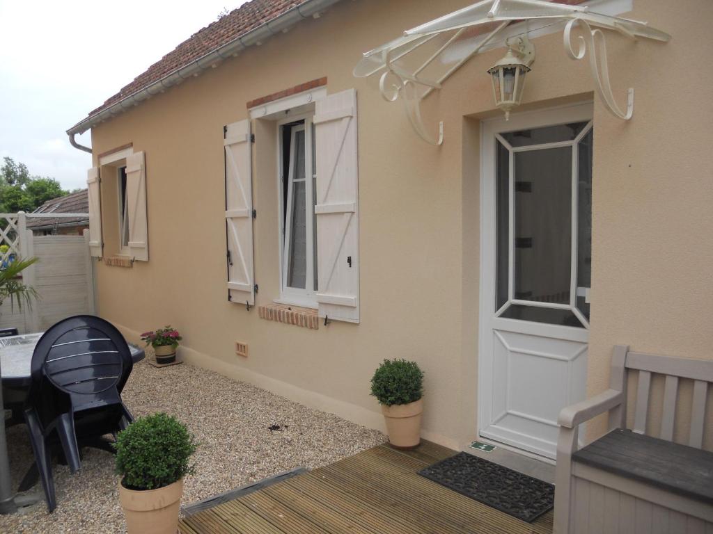 a house with a door and a table and chairs at Les Palerées, petite maison au coeur de la Sologne des Etangs in Saint-Viâtre