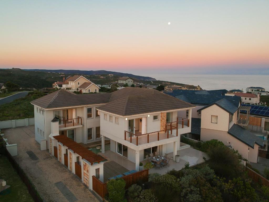 una vista aérea de una casa con la puesta de sol en el fondo en Pezula Fairlead Luxury, en Knysna