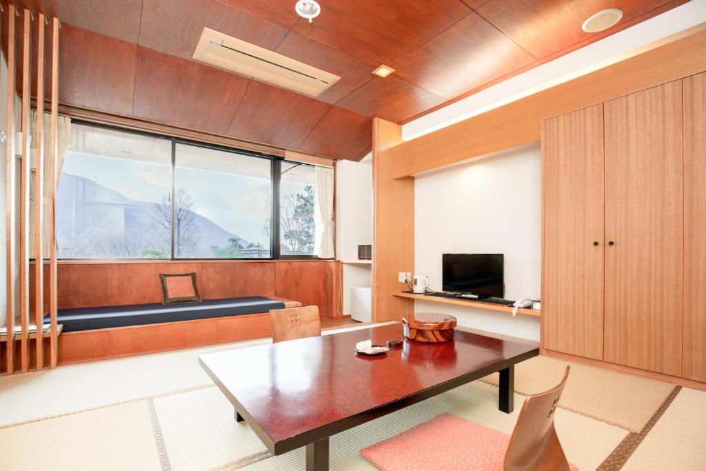 a living room with a table and a large window at Lalaca in Hakone