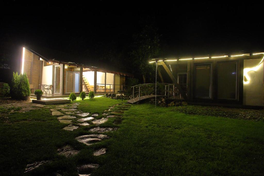 ein Haus in der Nacht mit Lichtern auf dem Gras in der Unterkunft Veranda in Slawske