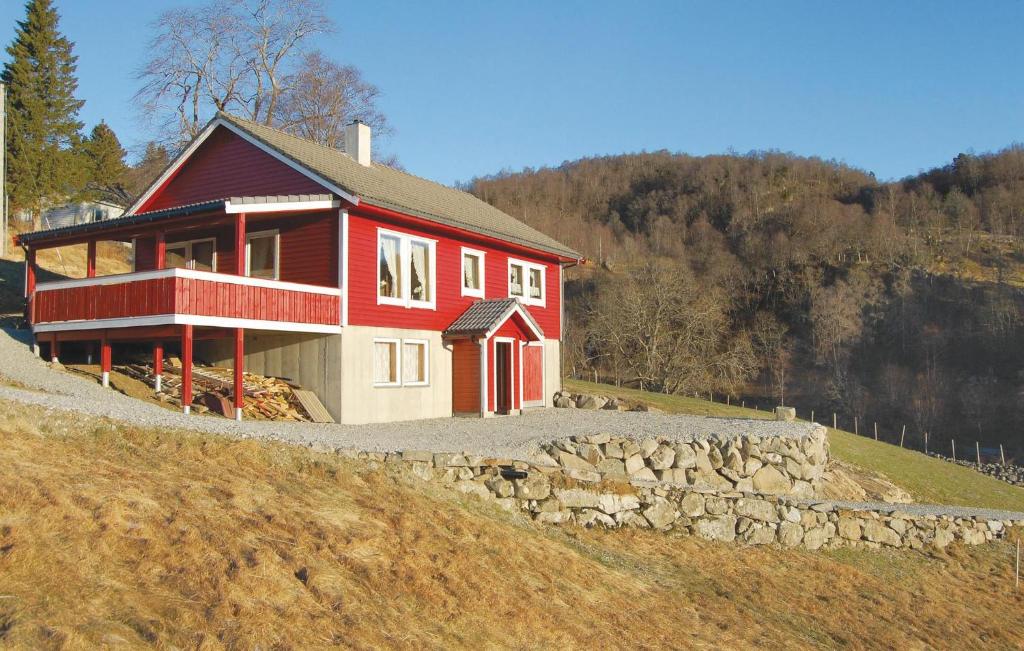 une maison rouge sur le côté d'une colline dans l'établissement Nice Home In Matre With 3 Bedrooms, à Bauge