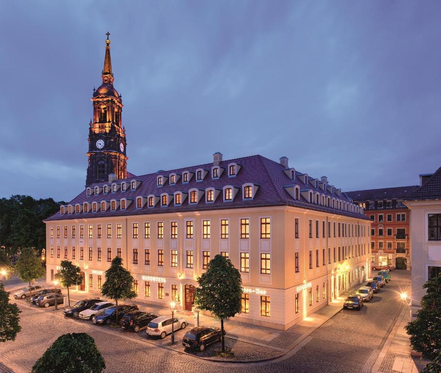 um grande edifício com uma torre de relógio em uma cidade em Relais & Châteaux Bülow Palais em Dresden