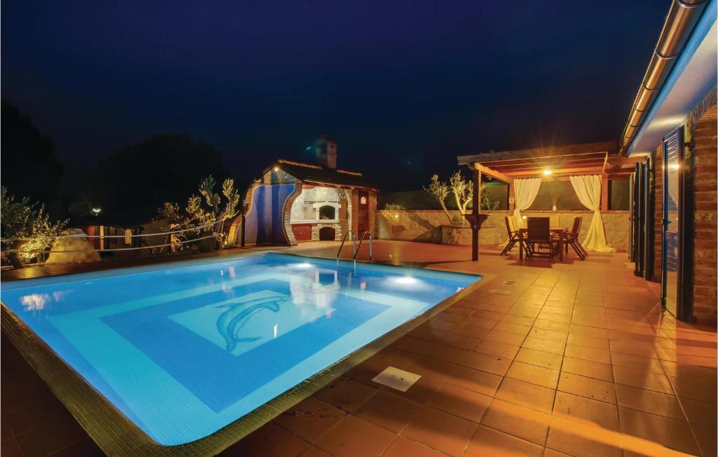 a swimming pool in a backyard at night at Gorgeous Home In Nerezine With House Sea View in Nerezine