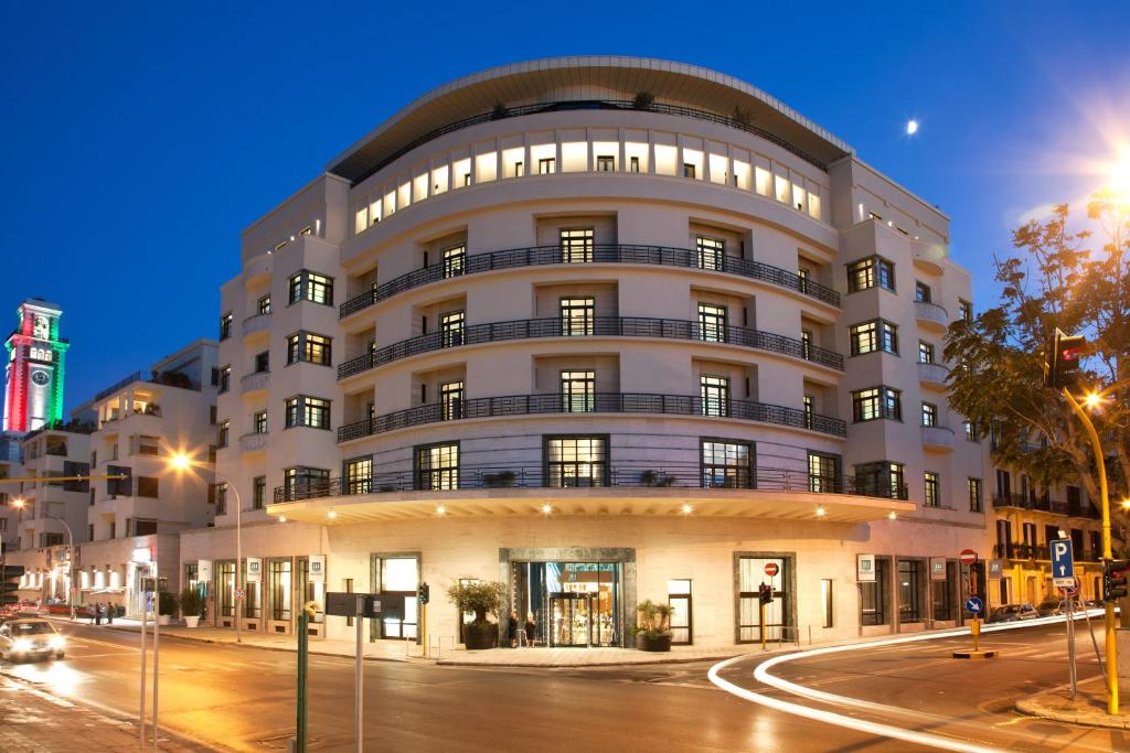 a large building on a city street at night at JR Hotels Bari Grande Albergo delle Nazioni in Bari