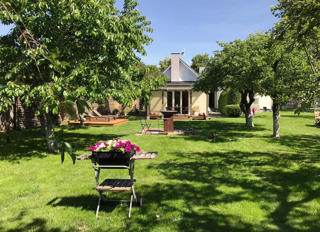 a picnic table with flowers on it in a yard at Namelis Palangoje in Palanga