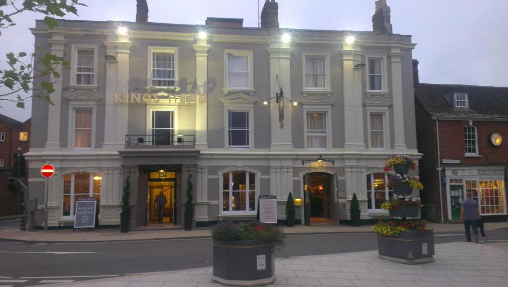 un grand bâtiment blanc au coin d'une rue dans l'établissement King's Head Hotel By Greene King Inns, à Wimborne Minster