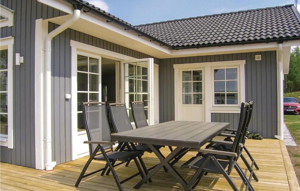 una mesa y sillas en una terraza con una casa en Amazing home in Bolms with 3 Bedrooms, Sauna and WiFi en Bolmsö