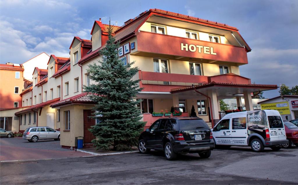 a hotel with cars parked in front of it at Hotel Dodo in Biłgoraj