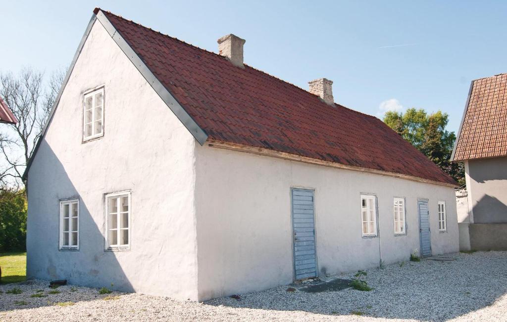 un antiguo edificio blanco con techo rojo en Gorgeous Home In Klintehamn With Kitchen, en Hejde