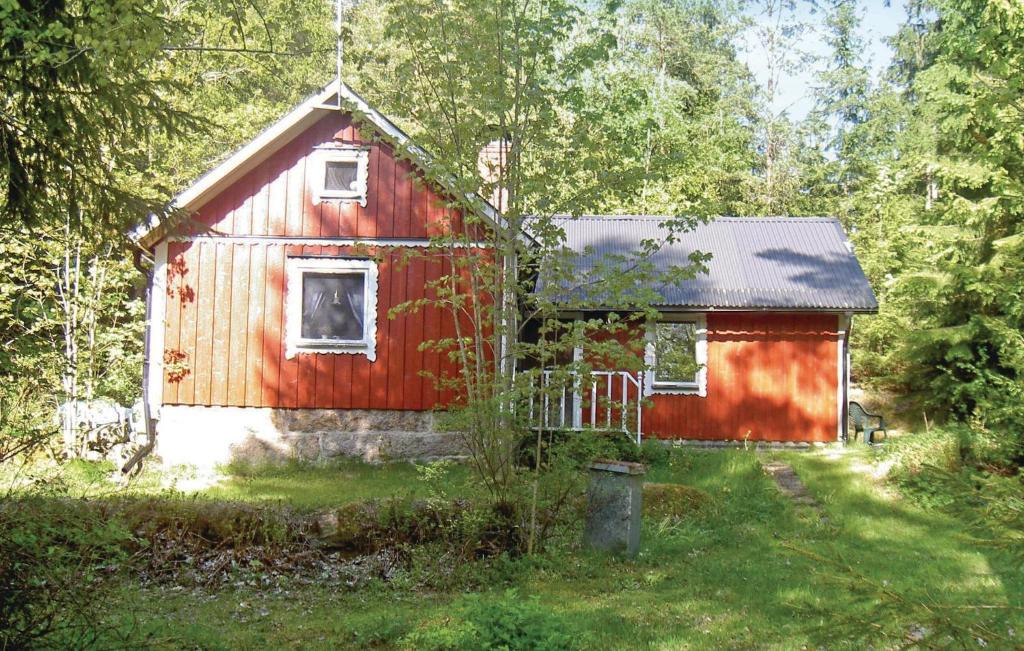 a red cabin in the middle of a forest at Nice Home In Ryd With 2 Bedrooms And Sauna in Ryd