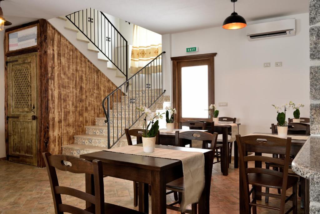 a restaurant with tables and chairs and a staircase at Hotel Goloritzé in Baunei