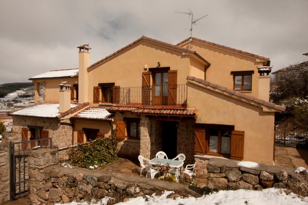 una casa con una mesa y sillas frente a ella en Casa de la Yaya, en Hoyos del Espino