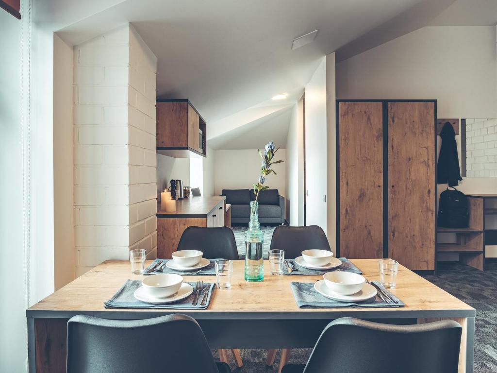 a dining room table and chairs in a kitchen at SELF CHECK-IN Hotel Railway Apartments in Vilnius