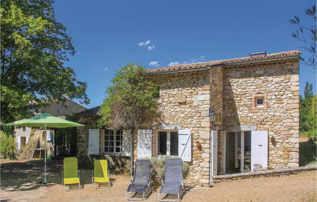 un gruppo di sedie e un ombrellone di fronte a un edificio di Amazing Home In La Begude-De-Mazenc a Truinas