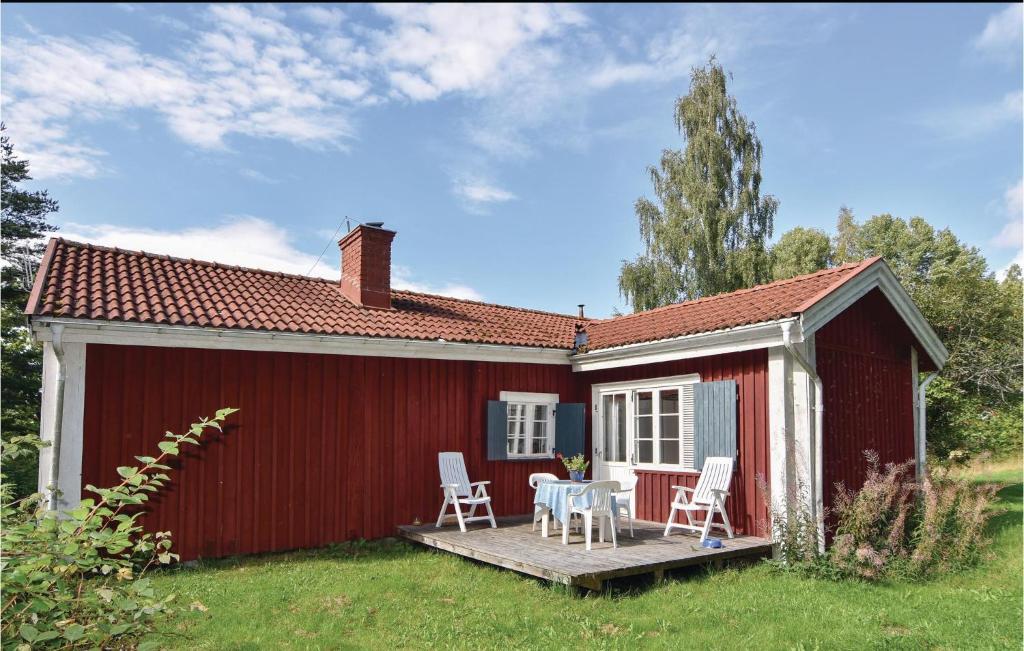 un cobertizo rojo con una mesa y sillas en una terraza en Stunning Home In Sffle With Sauna, en Säffle