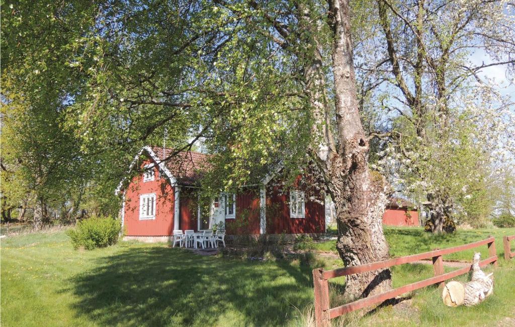 uma casa vermelha com uma árvore em frente em Beautiful Home In lmhult With 1 Bedrooms em Liatorp
