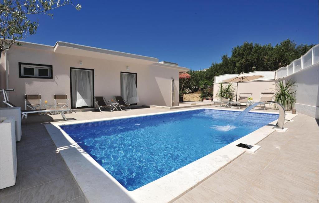 a swimming pool in front of a house at 3 Bedroom Gorgeous Home In Makarska in Makarska