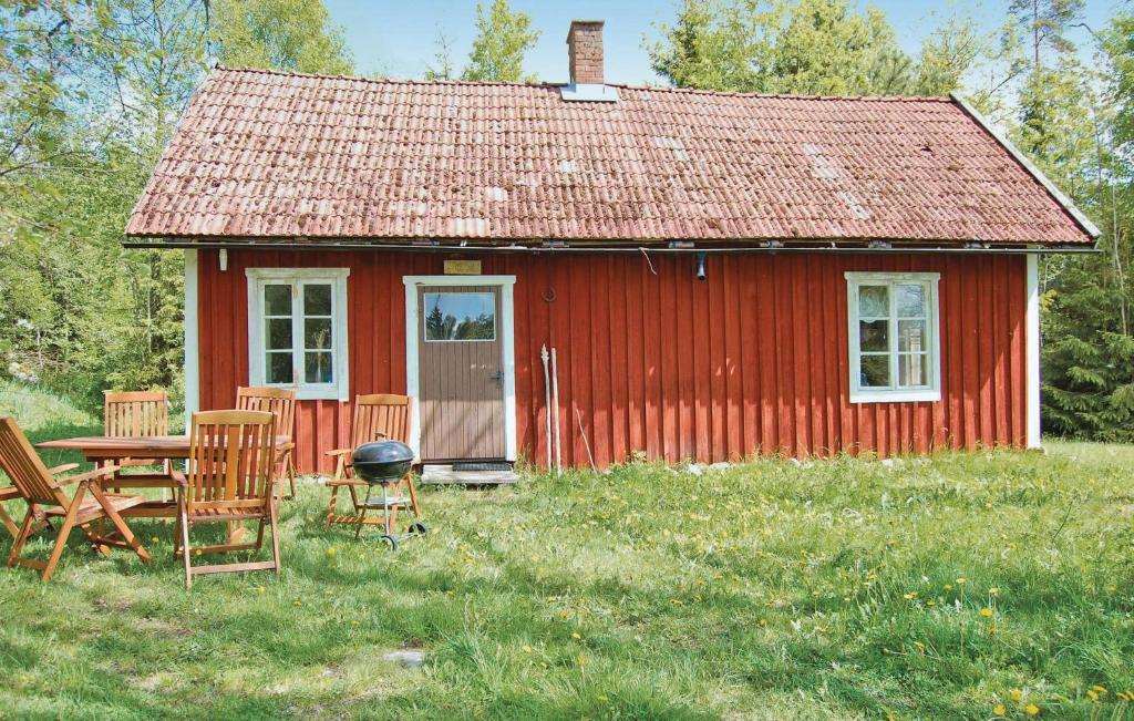 une maison rouge avec une table et des chaises devant elle dans l'établissement Kvighult, à Forsvik