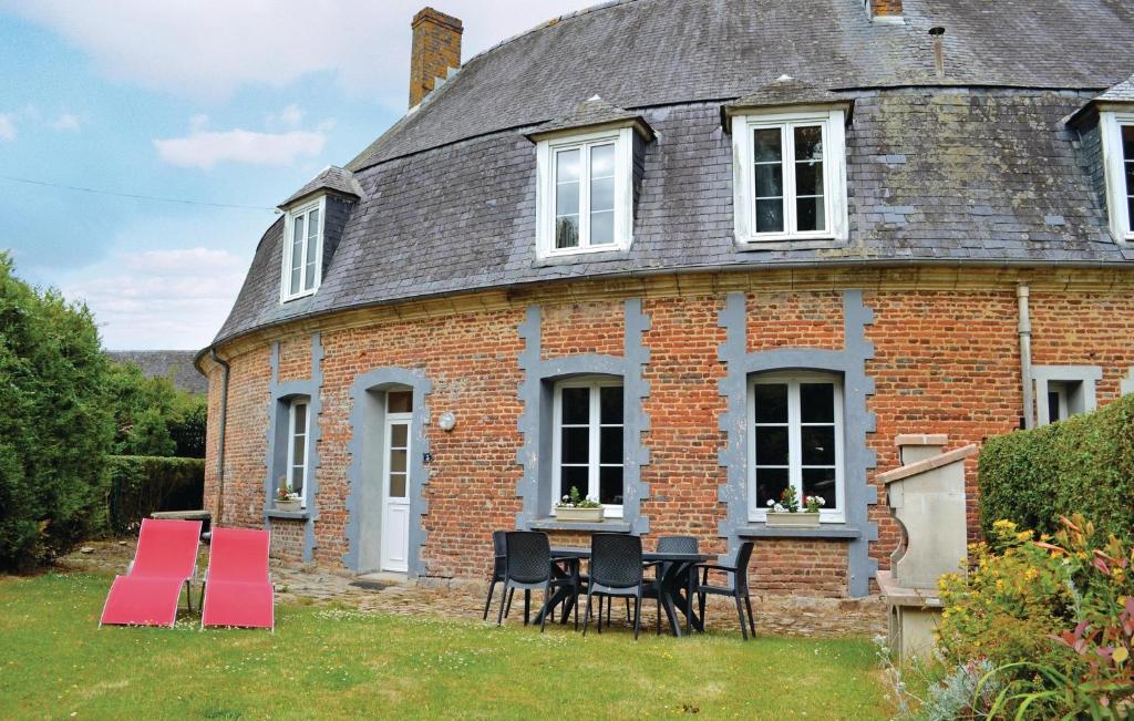 an old brick house with red chairs in the yard at Nice Home In Gouy St, Andre With Wifi in Gouy-Saint-André