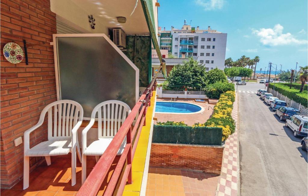 ピネダ・デ・マールにあるAmazing Apartment In Pineda De Mar With 2 Bedrooms And Outdoor Swimming Poolのバルコニー(椅子2脚、建物内のチョークボード付)