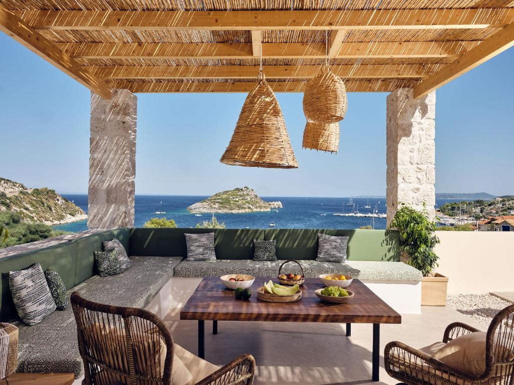 eine Terrasse mit einem Tisch und Stühlen sowie Meerblick in der Unterkunft Apaggio Villa in Agios Nikolaos