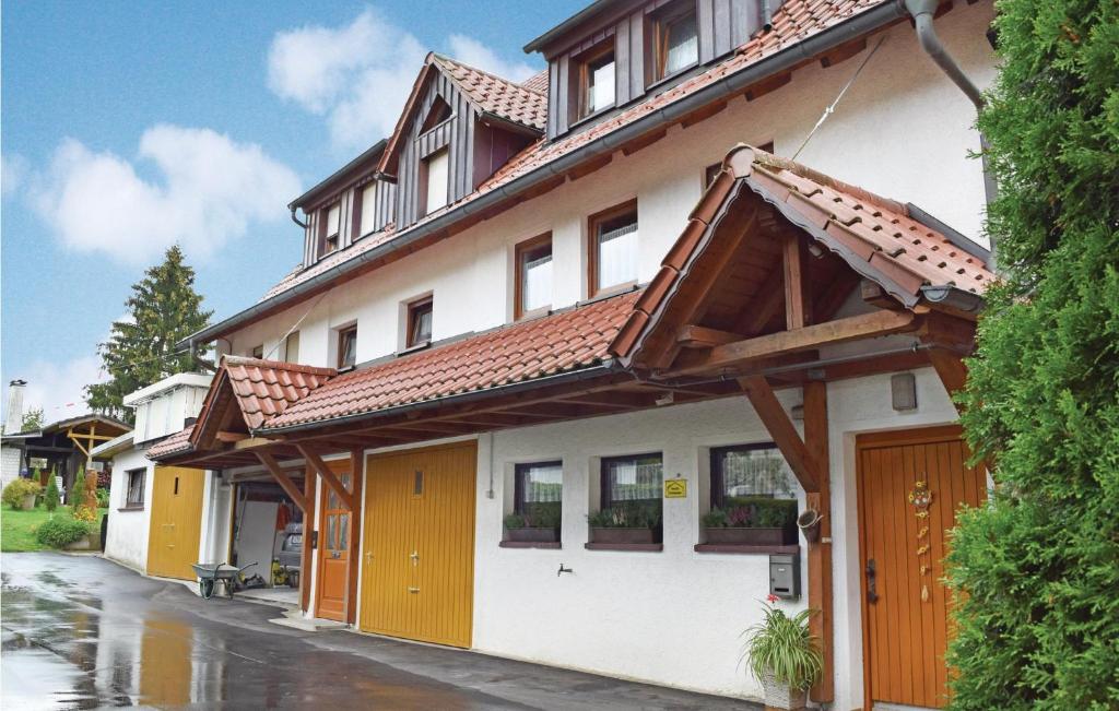 un edificio blanco con puertas naranjas en una calle en Amazing Home In Alpirsbach-rmlinsdorf With 2 Bedrooms, en Marschalkenzimmern