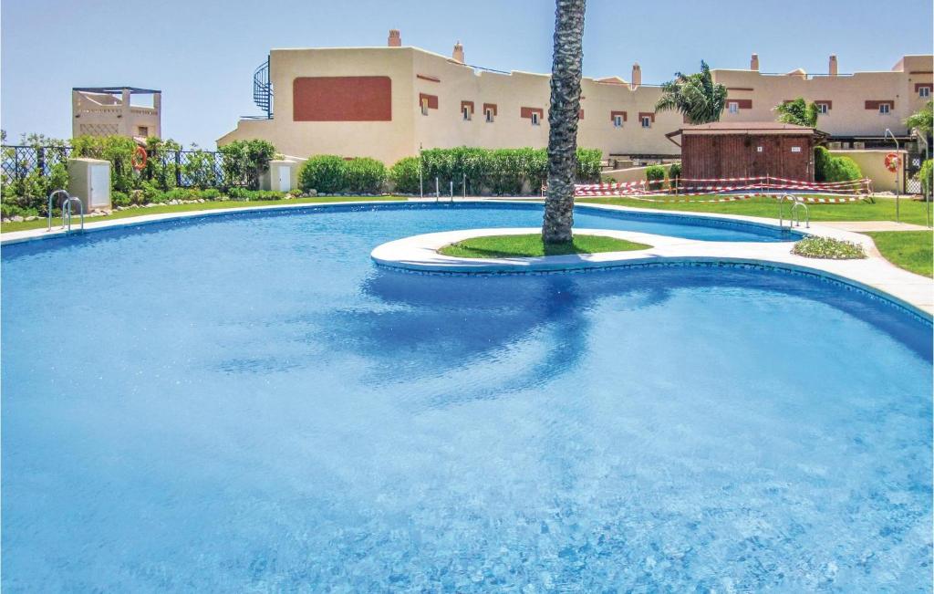 ラ・カラ・デ・ミハスにあるNice Home In Mijas Costa With 2 Bedrooms, Wifi And Outdoor Swimming Poolのヤシの木が立ち並ぶ大型スイミングプール