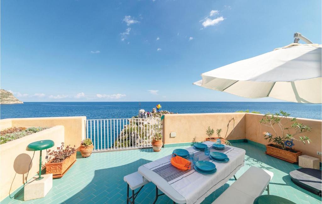 een patio met een tafel en een parasol en de oceaan bij Villa Kericia in Porticello